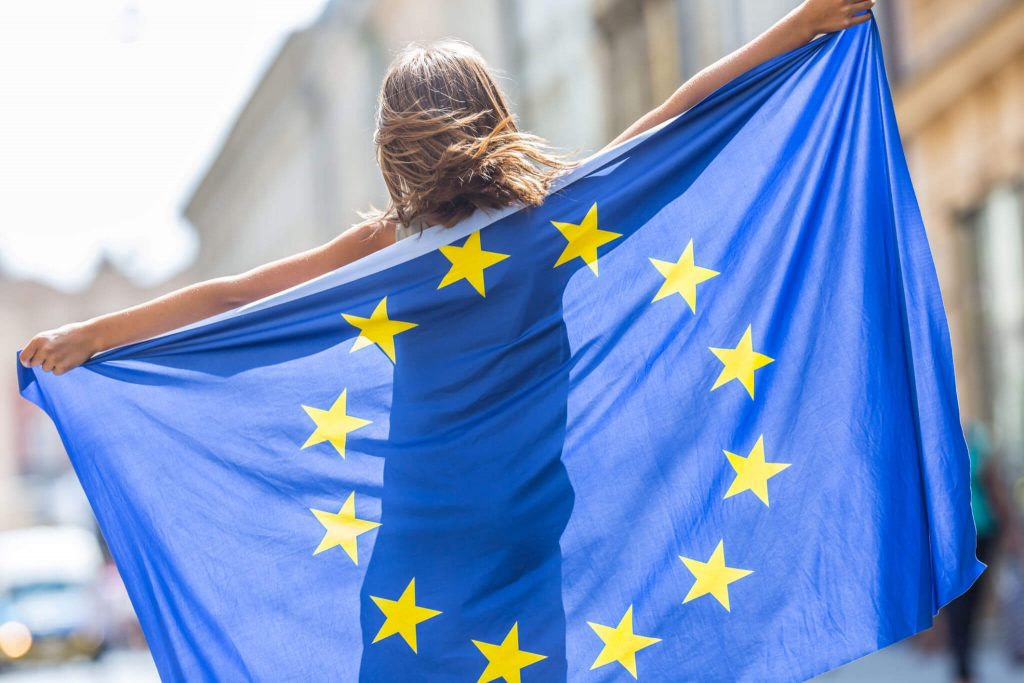 Chica joven con una bandera de la Unión Europea - En plan Europa